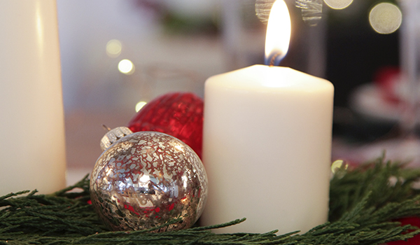 Remembering Loved Ones with a lit candle and a silver and red bauble