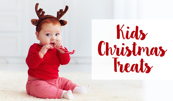 Kids Christmas Treats baby girl biting a candy cane treat - Christmas Treats for Kids
