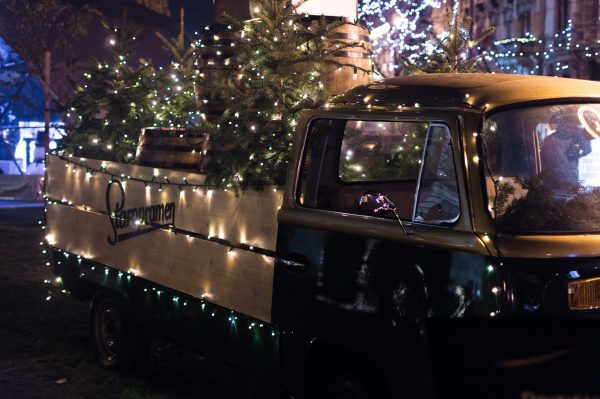 Christmas Vehicle Carrying some Christmas Trees with Christmas lights