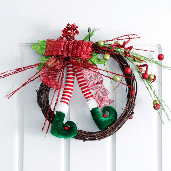 elf legs wreath hanging in a door - Creative Storage Tips for Your Christmas Decorations