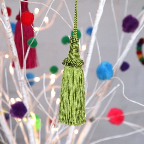 Green tassle Hanging in a white wooden stick tree with a different colour decoration
