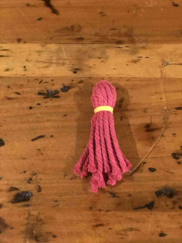 One Pink Tassles Placed in a wooden table