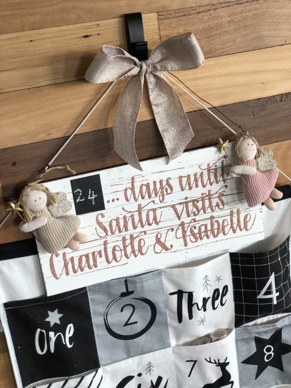 My Granddaughters Christmas Advent Calendar with 24 days until Santa Visits Charlotte & Isabelle Plaques hanging in a Wooden Wall