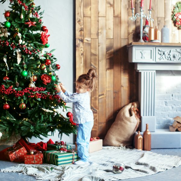 Little Girl In Pajamas Decorated Christmas Tree