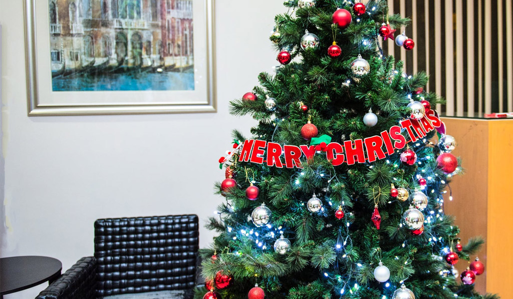 Huge Christmas Tree with a Merry Christmas Letter Hanging Featured Image