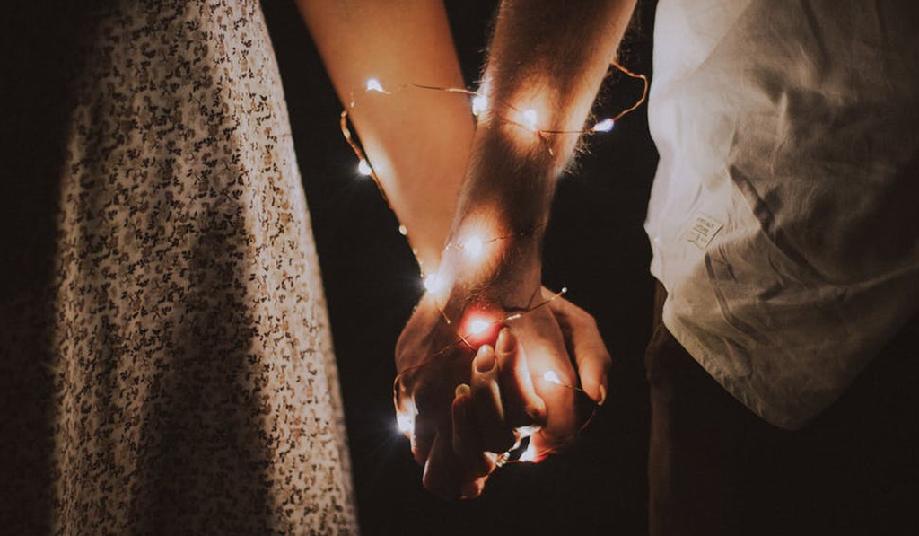 Couples holding hands with a String light Featured Image