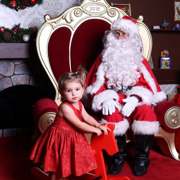 Visit Santa Strathpine - Little Girl wearing a red dress standing beside Santa