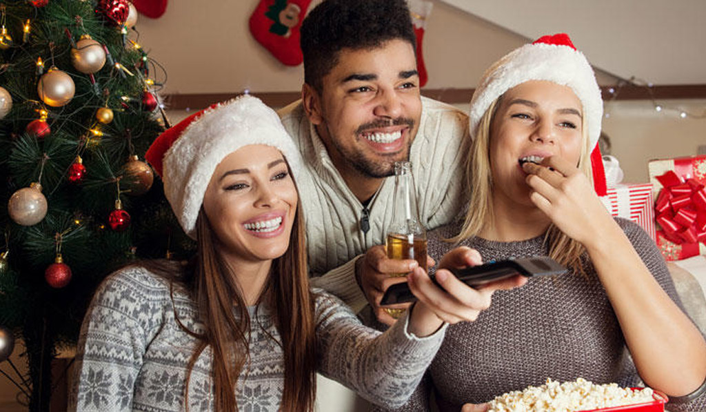 3 Friends watching a Christmas Movie and Wearing a Santa Claus Hat
