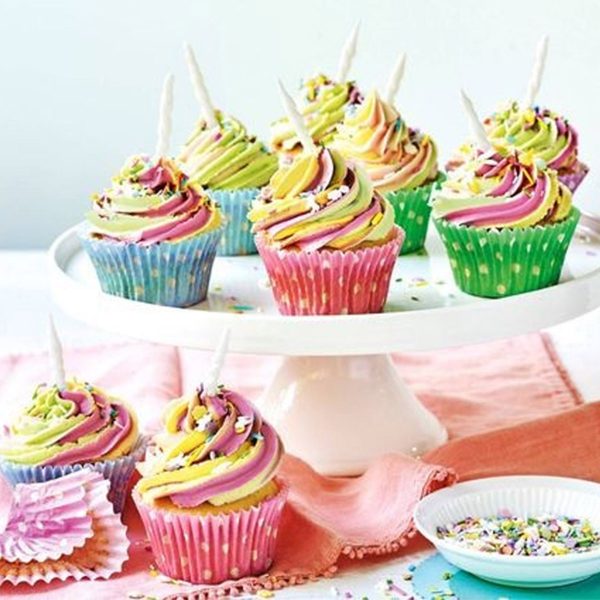 Colourful cupcakes with candle placed in a tray