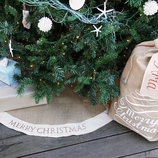 Burlap Tree Skirt Saying Merry Christmas Under A Christmas Tree and a Santa Sack Merry Christmas