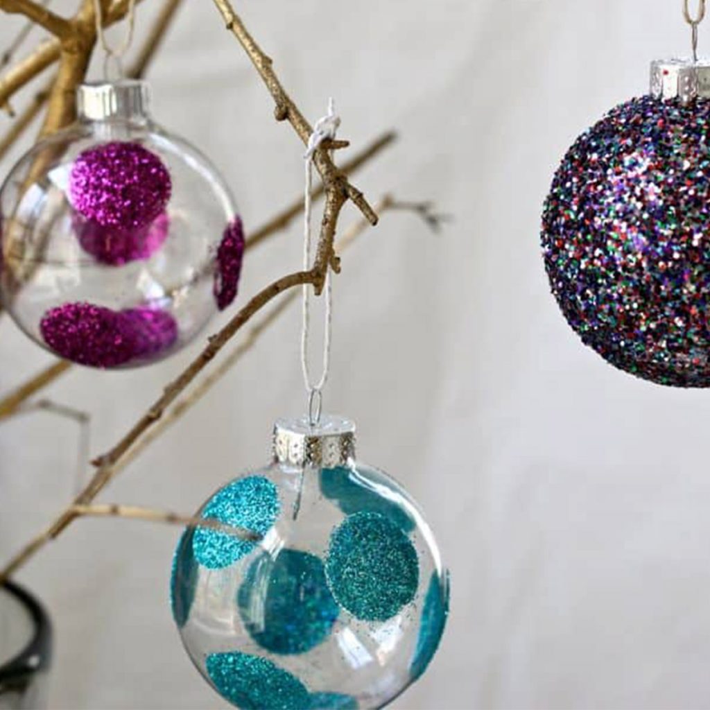 Christmas Clear Acrylic Craft Bauble with Glitter Design Hanging in a Branch
