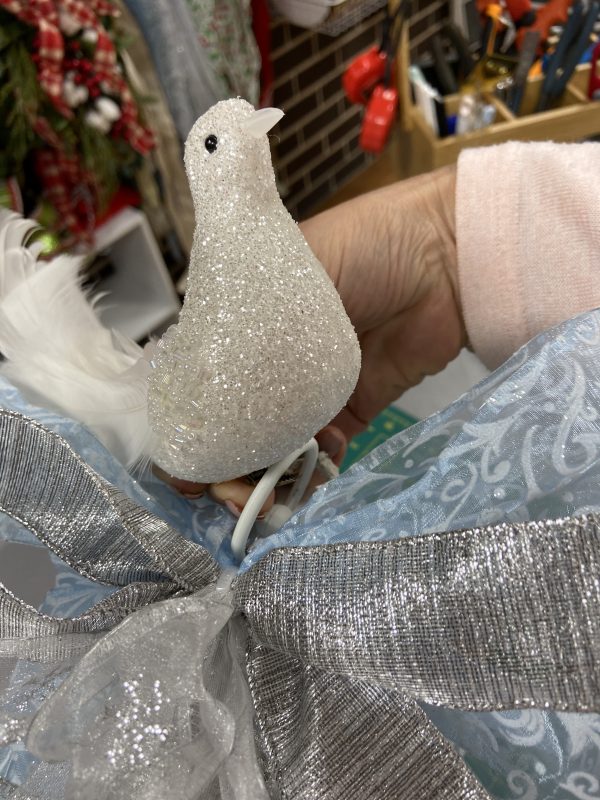 Holding the Silver Glitter Bird Ornament with Blue and Silver Ribbon