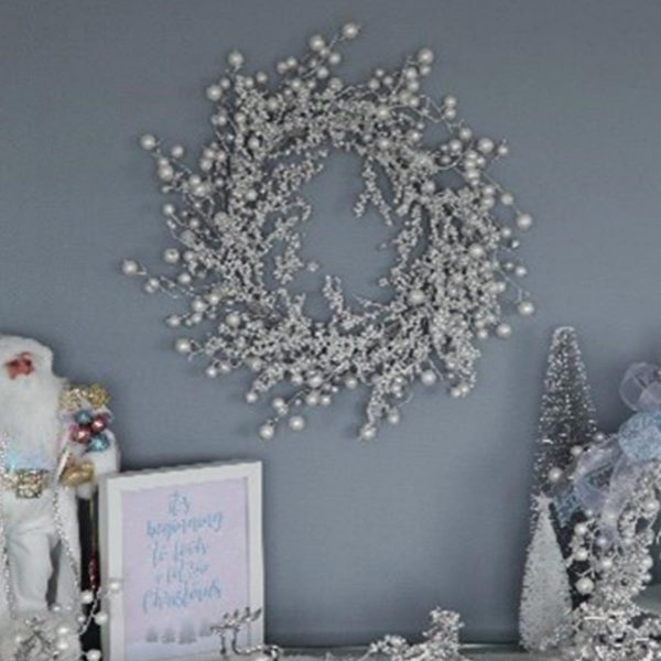 Silver Glitter and Pearl Twig Wreath Hanging in a Blue Wall