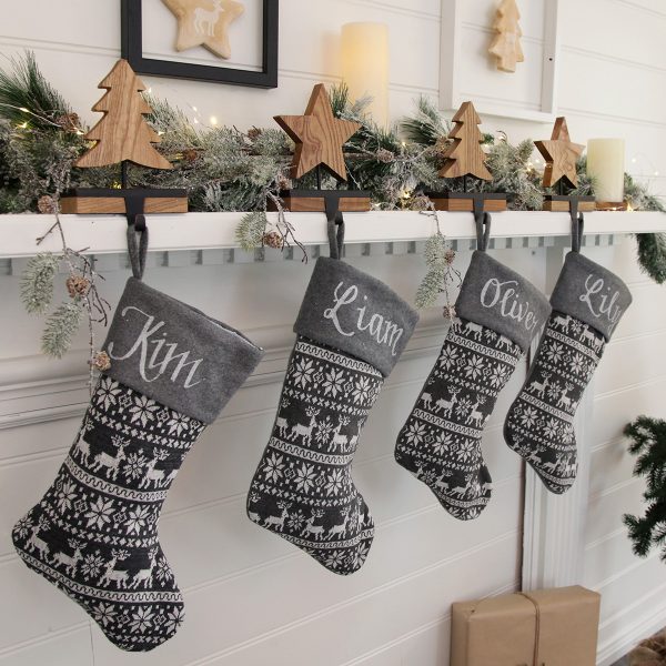 Grey Knitted Stockings hanging in a fire place with christmas hanger Lifestyle