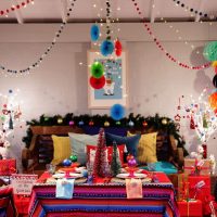Falalala Llama Christmas Fiesta night living room filled with multi coloured Decorations Christmas Santa Sacks