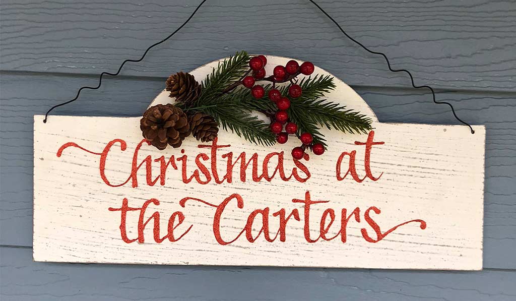 Christmas plaque with a red writing Christmas at the Carters hanging on a wooden hall