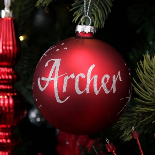 Personalised Red Glass Bauble Named Archer Hanging in a Christmas Tree