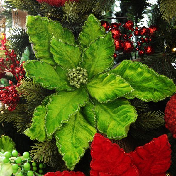 green poinsettia flower pick with green trim lifestyle placed in a Christmas Tree