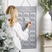 24 days of Christmas Kindness Calendar with a woman adding a card inside the number 8
