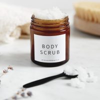 Body Scrub placed in a table with towel and brush