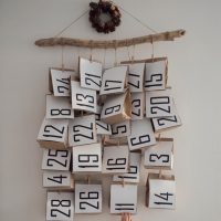 Calendar hanging in a twig until number 28 in a plain white wall