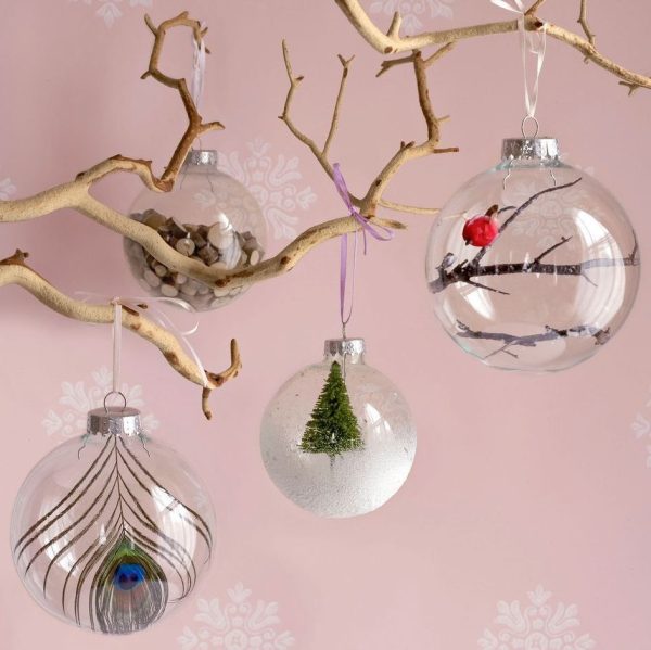 Homemade Christmas Ornaments Glass Snowglobe hanging in a branch with Pink background