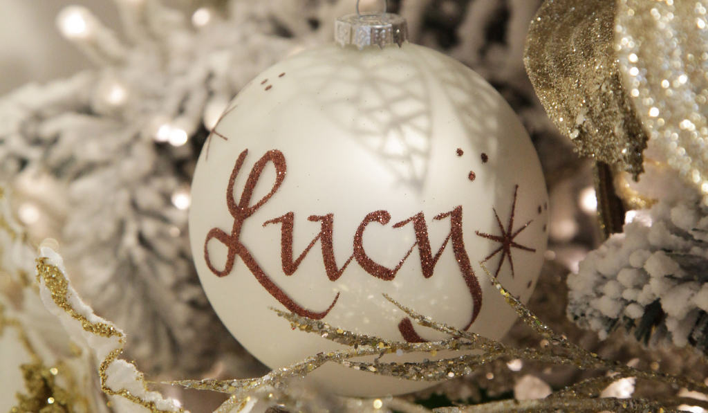 Christmas Joy Pearl Glass Personalised Christmas Bauble Named Lucy hanging in a Christmas tree