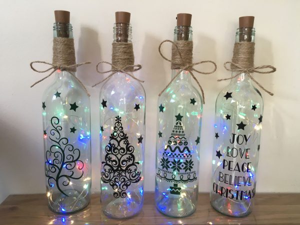 Pinterest Christmas light bottles placed in a wooden table