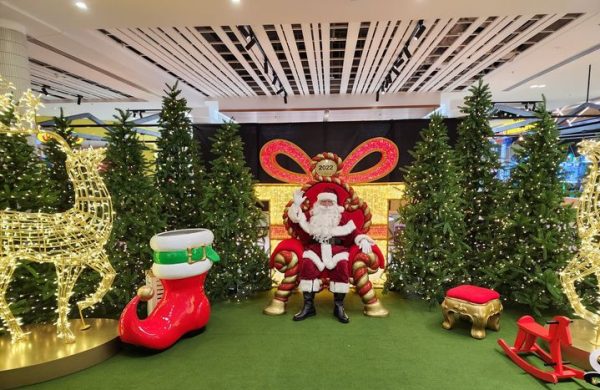 Santa sitting in his red chair inside a mall