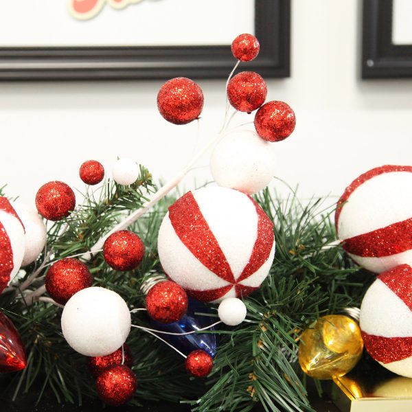 Glitter Candy Cane Ball Pick placed in a garland