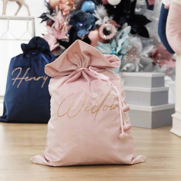 Personalised Pink Velvet Santa Sack Placed in front of the christmas Tree